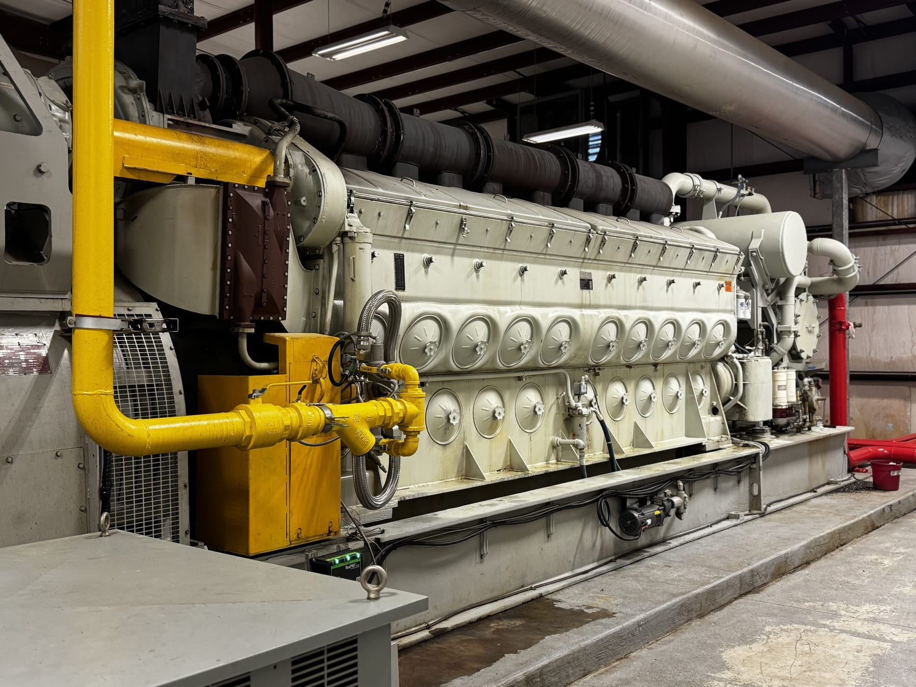 A large industrial backup generator engine inside the facility generator room